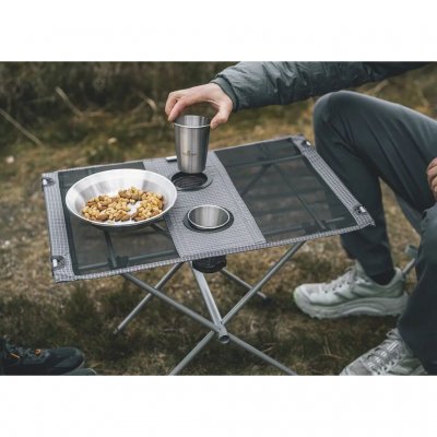 Small and low table with a steel frame and tabletop made of polyester and mesh.