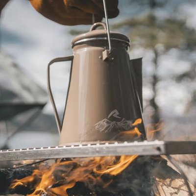 Khaki-colored enamel kettle from Robens with a bail handle for hanging on a hook over the fire.